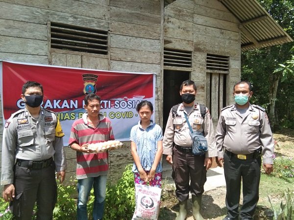 Kapolsek Alasa Ipda Sahabat Zebua bersama personel saat membagikan sembako ke rumah salah seorang warga kurang mampu/foto:istimewa