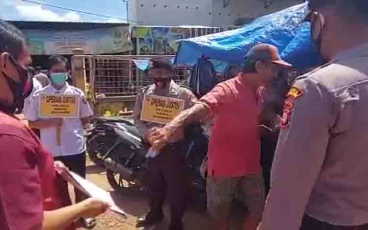 Pria berbaju merah yang merobek masker dari Kapolsek Parenggean, Iptu Agung Gunawan - Foto.dok.Borneonews