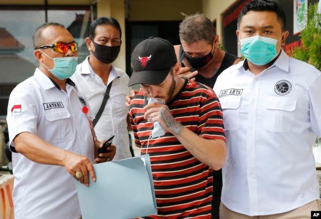 Collum Park (tengah), dan Aaron Wayne Coyle (belakang), dikawal ketat polisi di markas Polda Denpasar, Kamis, 3 September 2020 - Foto:AFP/VoA